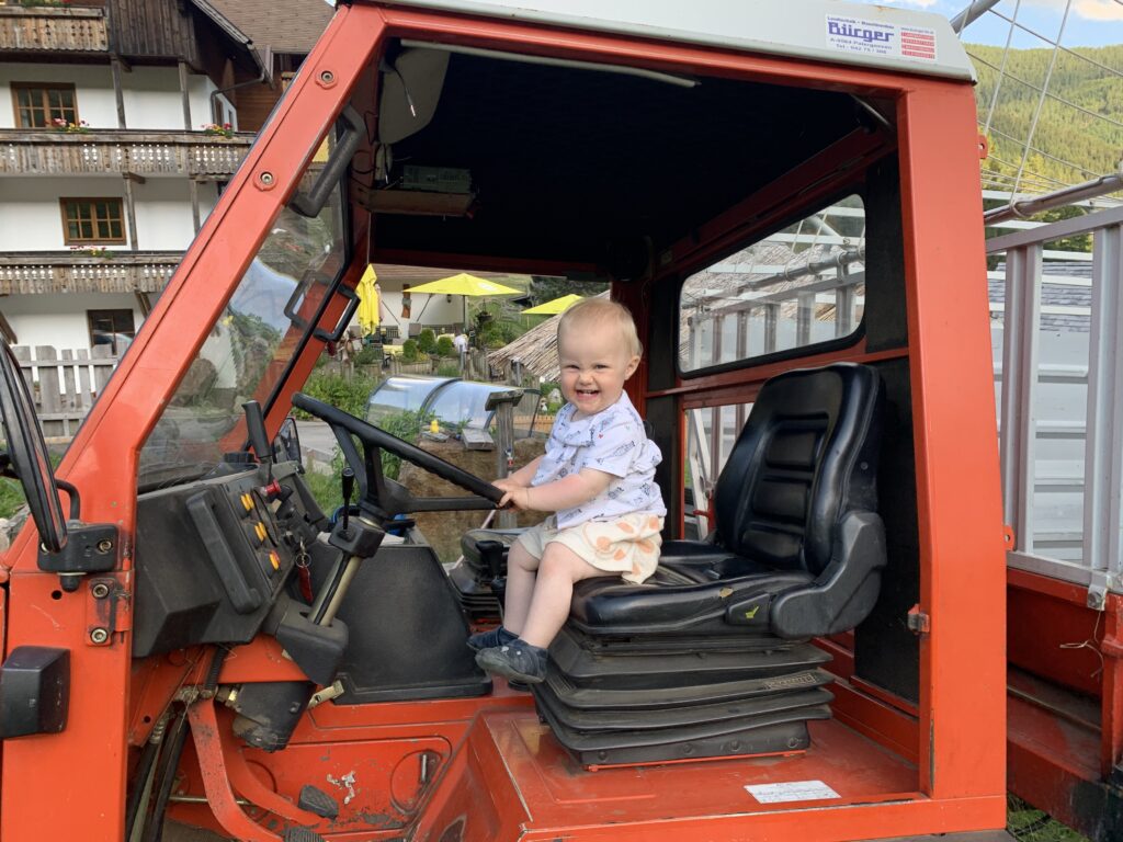 Urlaub am Bauernhof - Kind sitzt in Traktor